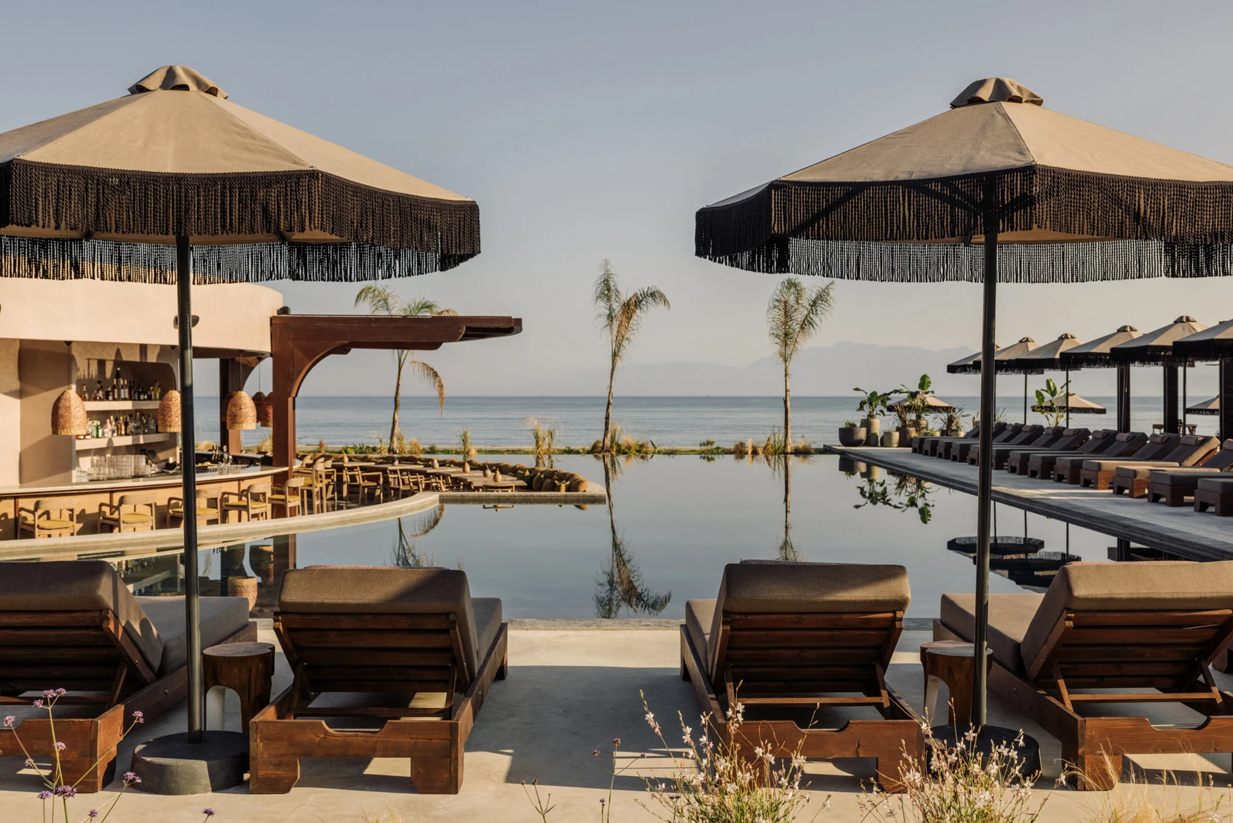 Sunbeds under fringed parasols