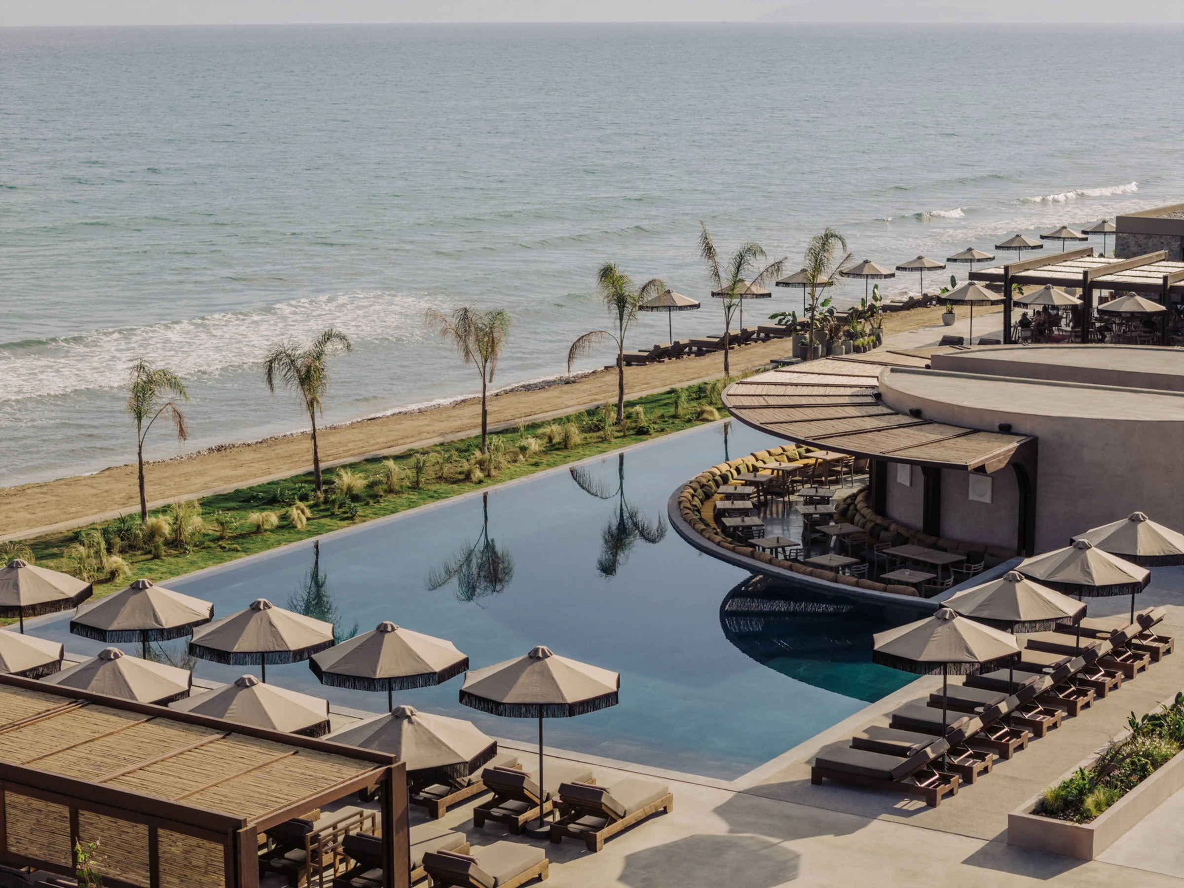 Pool, palms and beach side by side